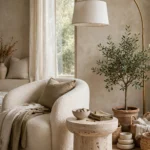 Curved boucle armchair, travertine side table, arched lamp and olive tree